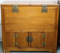A 20th century Oriental hardwood chest with two lidded compartments over pair of cabinet doors on