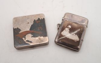 A Japanese silver niello compact, decorated with mountain scenes, and a pictorial silver vesta, by B