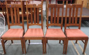 A set of four late Victorian oak Glasgow style Arts & Crafts chairs with slated backs carved with