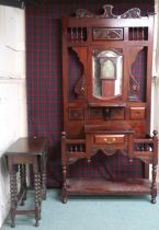 A 20th century mahogany hallstand with carved surmount over bevelled glass mirror over single drawer