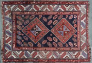 *WITHDRAWN* A dark blue ground Heriz rug with two red diamond shaped medallions and multicoloured