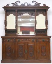 A LATE VICTORIAN STAINED OAK ARTS & CRAFTS MIRROR BACKED SIDEBOARD  with scrolled surmount over