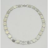 A WILHELM MULLER NECKLACE of hammered silver discs linked with rings. The end link marked with