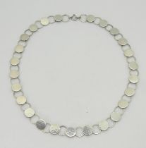 A WILHELM MULLER NECKLACE of hammered silver discs linked with rings. The end link marked with