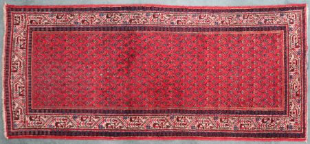 A RED GROUND ARAAK RUNNER  with geometric multicoloured borders, 216cm long x 95cm wide Condition