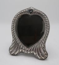 A LATE VICTORIAN SILVER FRAMED HEART-SHAPED MIRROR by William Comyns, London 1896, the fluted
