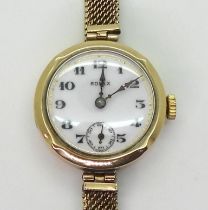 A LADIES VINTAGE ROLEX in 9ct gold, the white dial with subsidiary seconds dial blued steel hands,