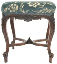 A VICTORIAN WALNUT FRAMED STOOL  with floral upholstered seat on carved cabriole supports joined