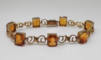 A CITRINE BRACELET mounted in 9ct gold with pretty scroll shaped links, each citrine is approx