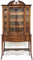 A LATE VICTORIAN WALNUT AND SATINWOOD INLAID DISPLAY CABINET  with shaped cornice over bow front