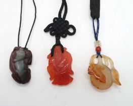 THREE CHINESE HARDSTONE PENDANT NECKLACES a fruit, 3.5cm long, figure, 4cm long and oxen, 4cm wide