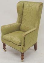 A VICTORIAN GREEN DAMASK UPHOLTERED WINGBACK ARMCHAIR  with high winged back on turned front