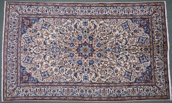 A CREAM GROUND NAIN RUG  with a blue and red central medallion, matching spandrels on all-over