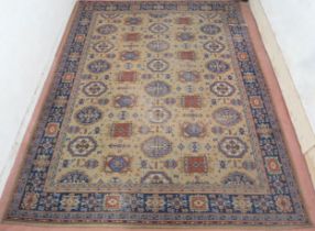 A LARGE BEIGE GROUND JAMES TEMPLETON & CO LTD STYLE RUG  with all-over multicoloured lozenge