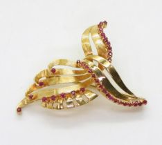 A RUBY BROOCH set in bright yellow metal, with engraved texture. Dimensions 3.5cm x 4.5cm, weight