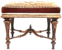 A 19TH CENTURY WALNUT FRAMED STOOL  with tapestry upholstered seat on extensively carved turned