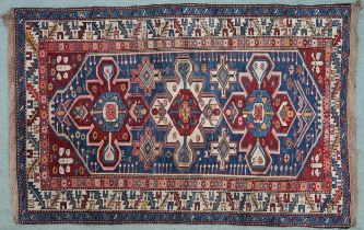 A BLUE GROUND CAUCASIAN KAZAK RUG  with three red and beige medallions on geometric pattern ground