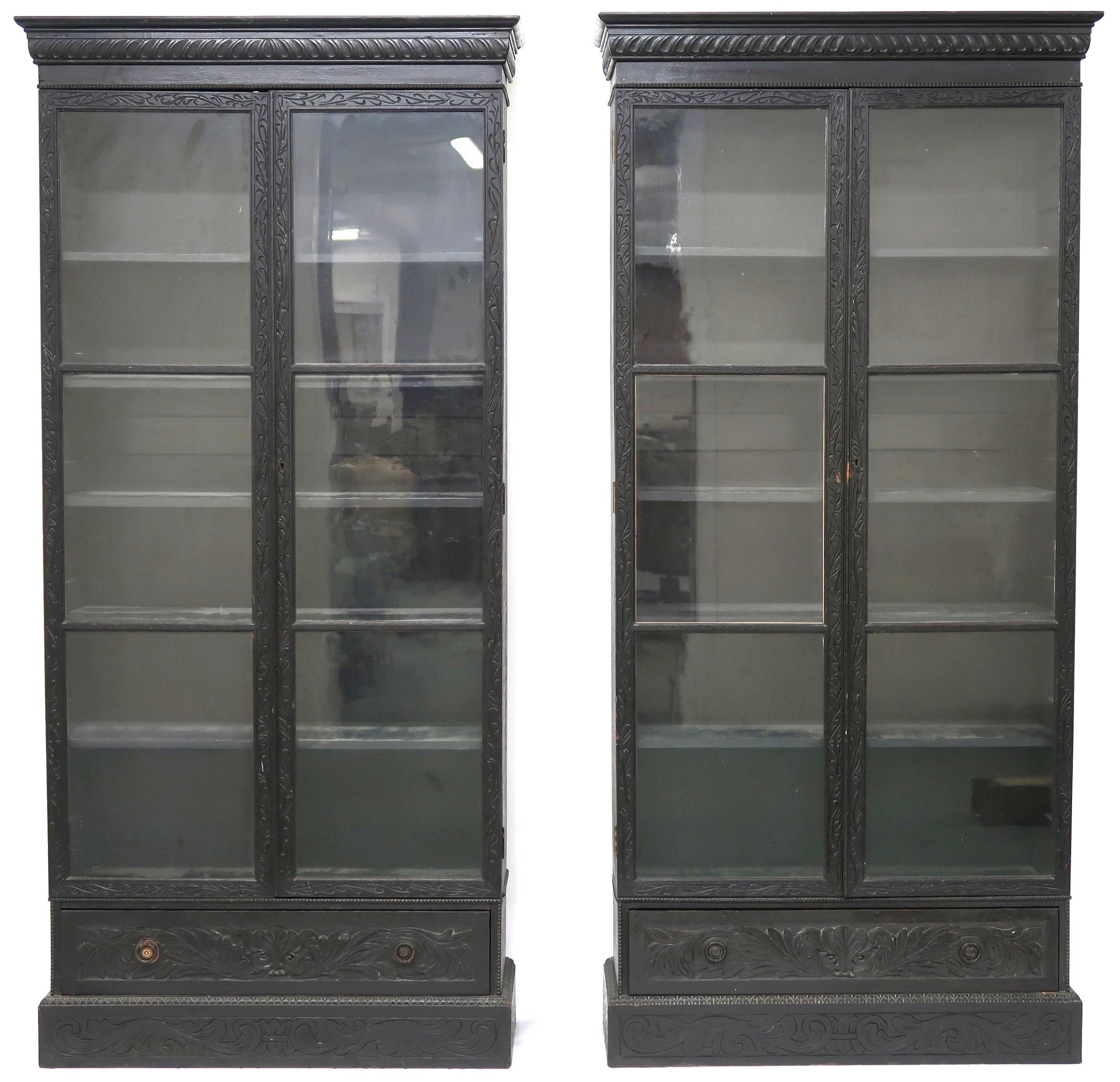 A PAIR OF 20TH CENTURY EBONISED GLAZED BOOKCASES  with gadrooned moulded cornices over pairs of