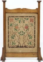 A LATE VICTORIAN OAK FRAMED GLASGOW STYLE FIRE SCREEN  with central panel decorated with floral