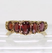 A five stone garnet ring, with a scroll mount, finger size U, weight 4.4gms Condition Report: