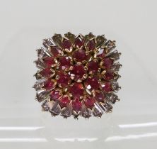 A yellow metal large retro cluster ring, the shank stamped '18' set with rubies and diamond accents,
