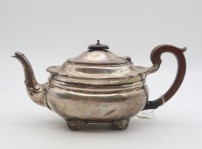 A George V silver teapot, London 1928, of squat oval form, on four bracket feet, with a scrolling