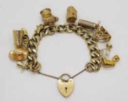 A 9ct gold charm bracelet with heart shaped clasp, to the heavy curb link chain, with eleven charms,