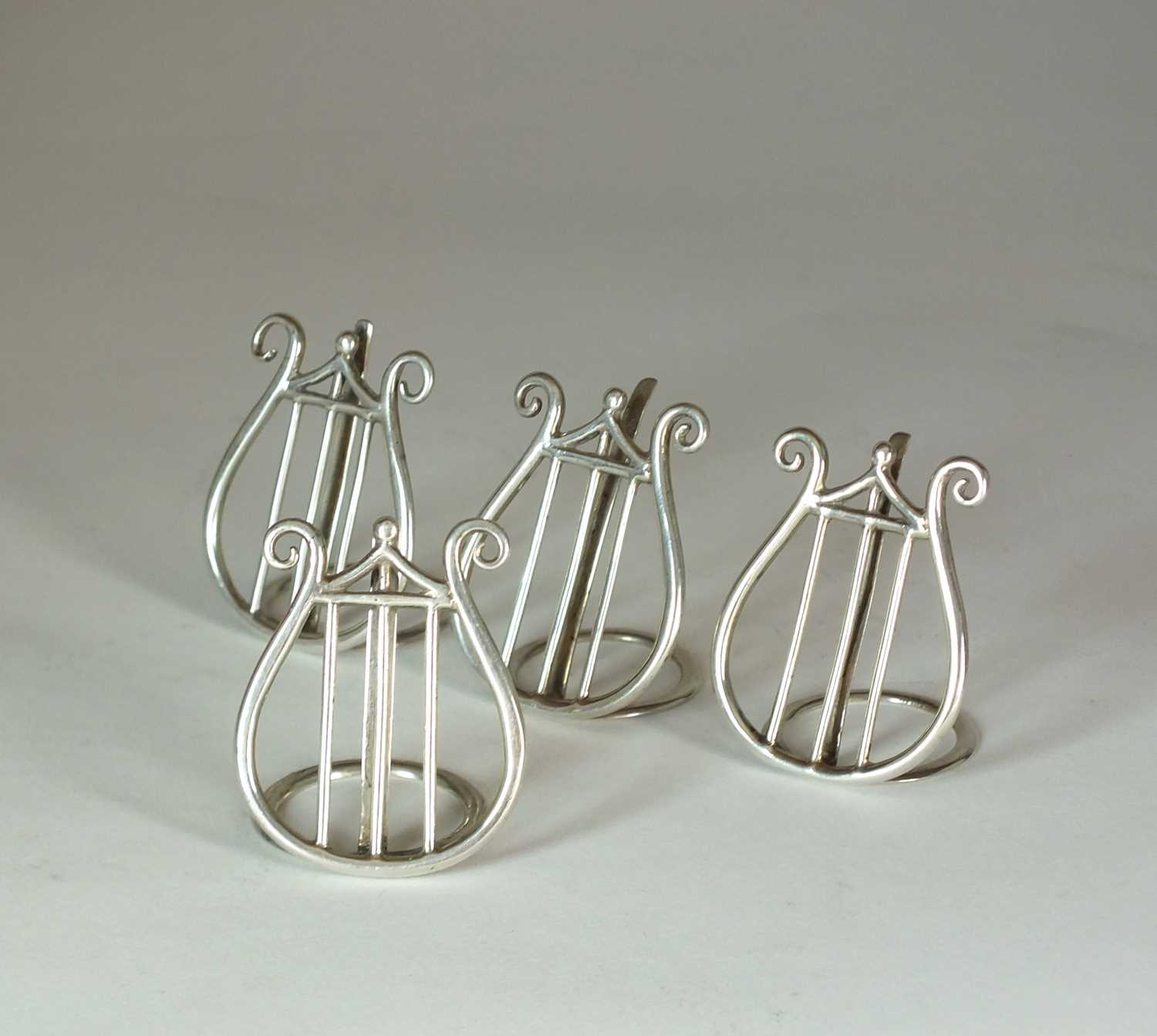 A set of four silver menu holders