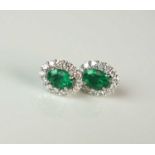 A pair of emerald and diamond oval cluster earrings