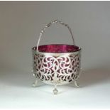 A Victorian pierced silver sugar basket with cranberry glass liner