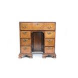 A George II style feather-banded walnut secretaire kneehole desk