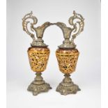 A pair of Rococo style cast pierced and enamelled spelter ewers