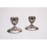 A pair of white metal Middle Eastern candlesticks