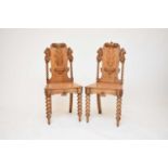 A pair of Victorian carved oak hall chairs