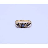 A yellow metal graduated five stone sapphire and diamond ring