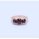 A 9ct gold three stone graduated garnet ring