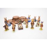 Fifteen Royal Doulton Bunnykins figures and a Beswick display stand