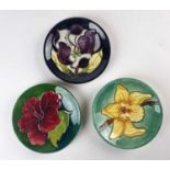 Nine Moorcroft pin dishes including Hibiscus, Hellebore and Coneflower