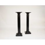 A pair of late Victorian ebonised wood torchere stands