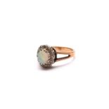 An oval opal and diamond cluster ring