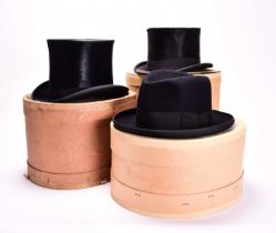 Two black silk top hats and one homburg, boxed