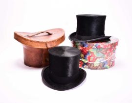 Two black silk top hats, one in leather case