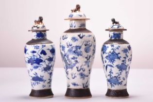 A pair of Chinese blue and white crackle-glazed vases and covers and another similar