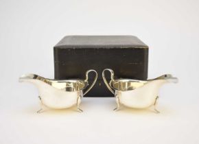 A cased pair of silver cream jugs