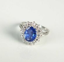 An oval sapphire and diamond cluster ring