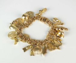 A yellow metal double scroll link bracelet with attached charms