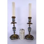 A PAIR OF 19TH CENTURY FRENCH CHAMPLEVE ENAMEL BRONZE CANDLESTICKS decorated with foliage. 44 cm hig