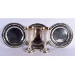 A PAIR OF SILVER PLATED BEAKERS together with three plates. Largest 24 cm long. (5)