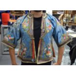 A LATE 19TH CENTURY CHINESE BLUE CHILDS SILK WORK EMBROIDERED JACKET decorated with foliage. 105 cm