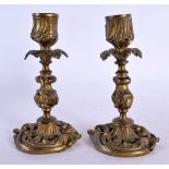 A SMALL PAIR OF 19TH CENTURY FRENCH BRONZE CANDLESTICKS of scrolling rococo form. 9 cm high.
